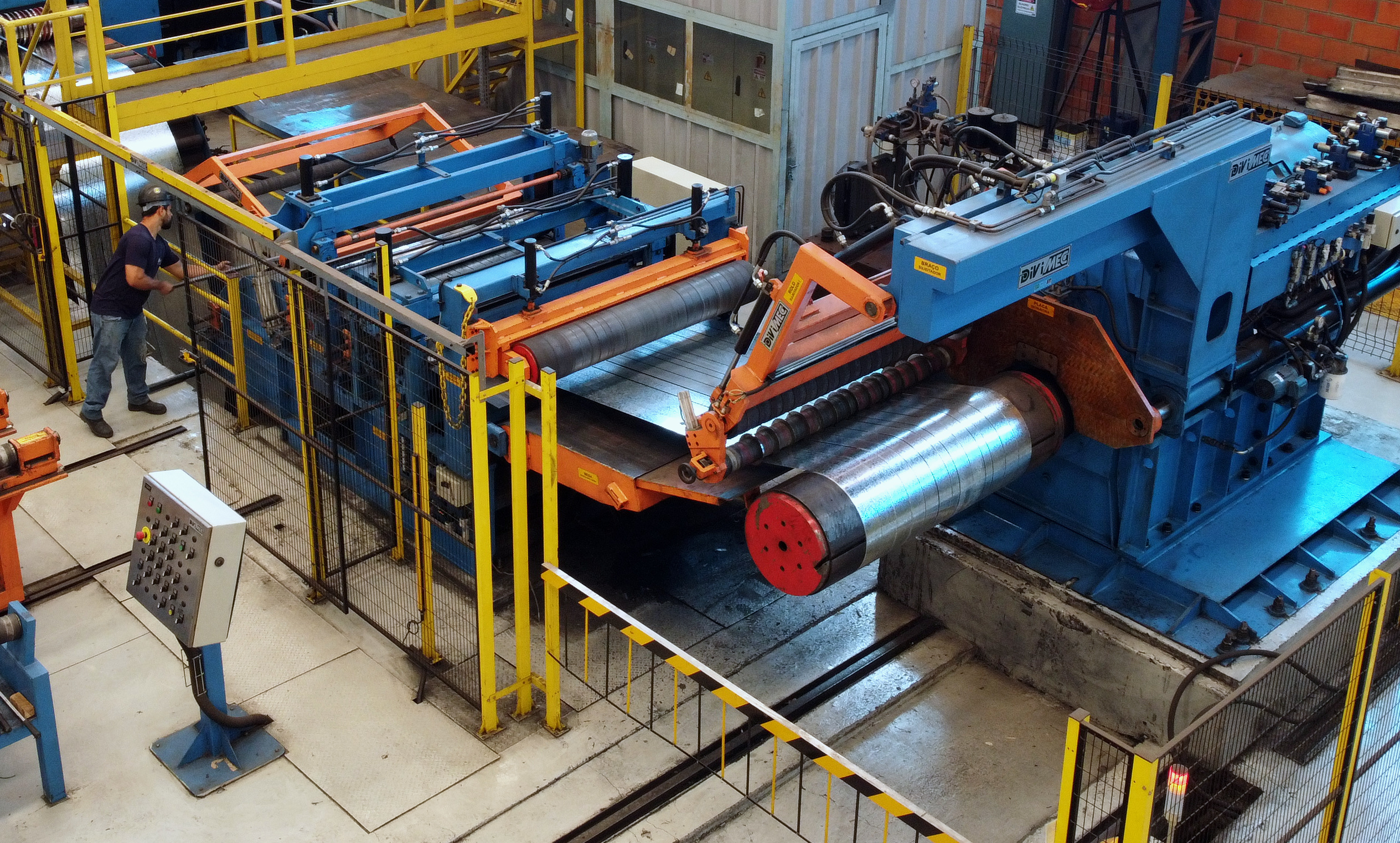 Máquina de Slitter Vista aérea, pode-se ver um colaborador trabalhando em uma máquina de Slitter.